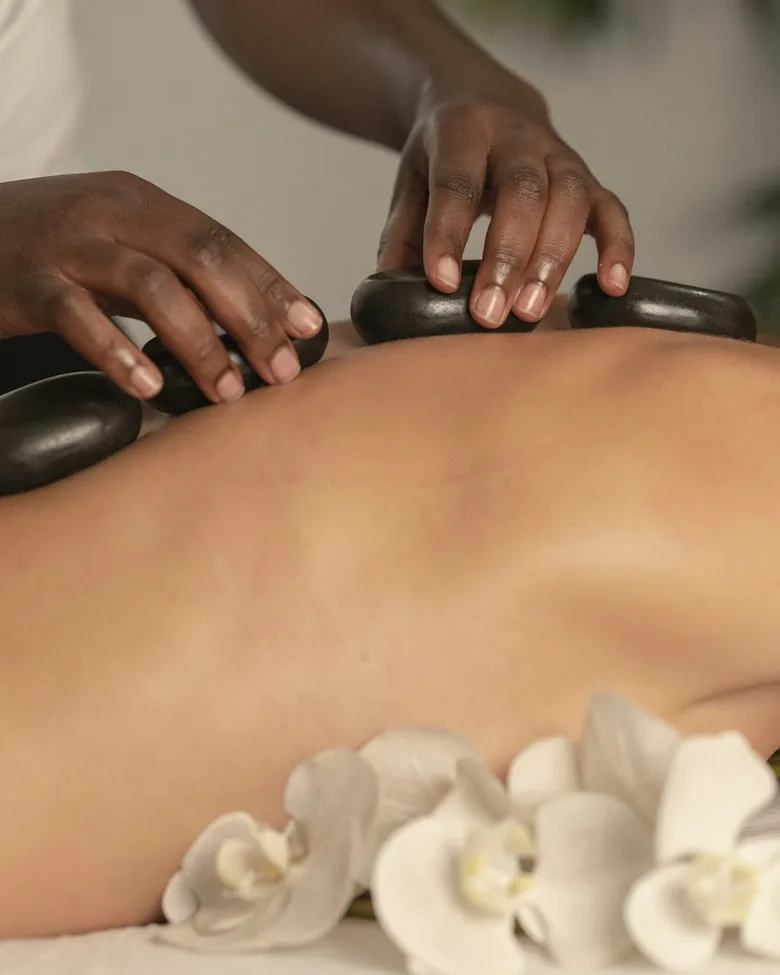 Masaje con piedras calientes y flores blancas