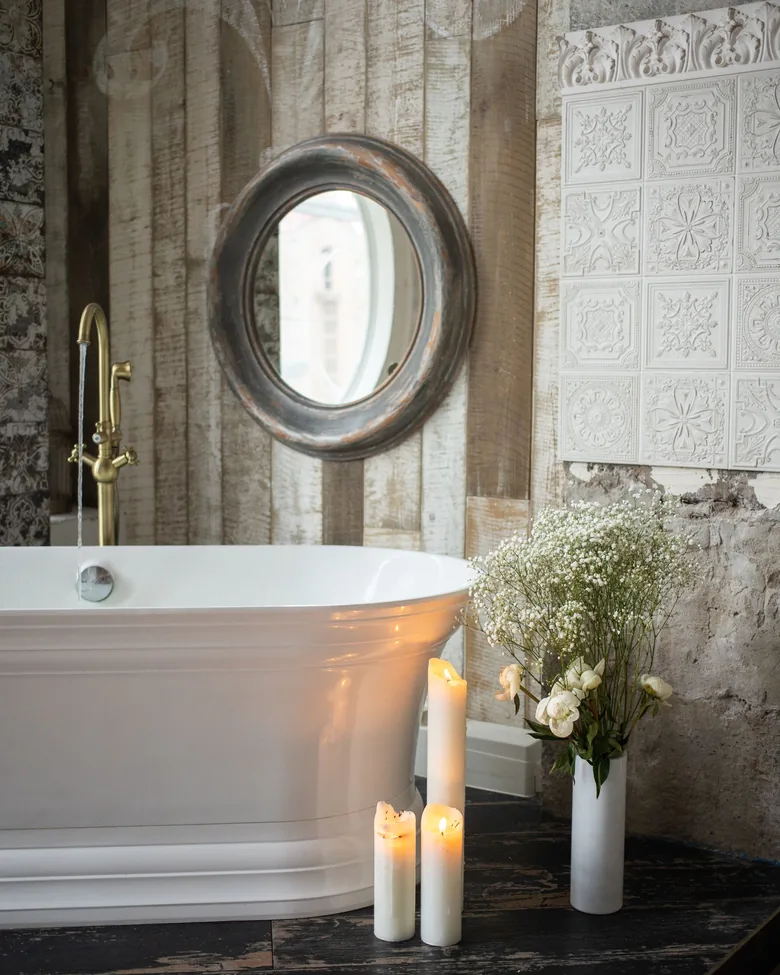 Tina con velas y flores en un baño de estilo clásico